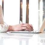 Schrijver druk aan het werk achter de laptop